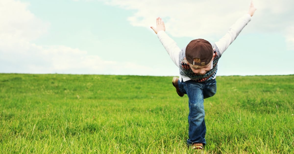 young boy playing in grass after using famzoo