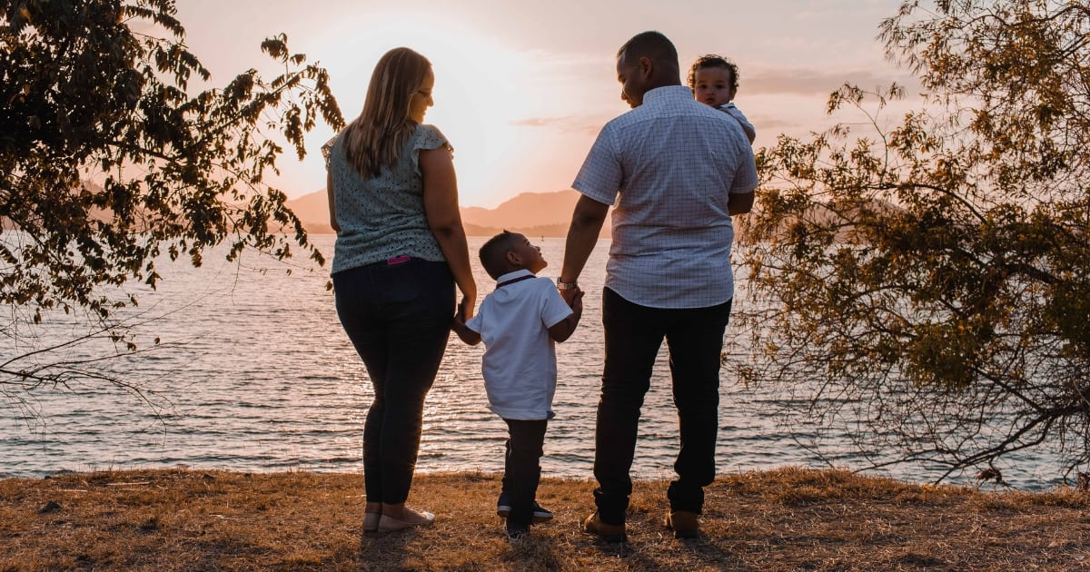 family with life insurance watching the sunset beachside