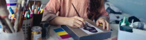 woman painting picture to sell on Etsy