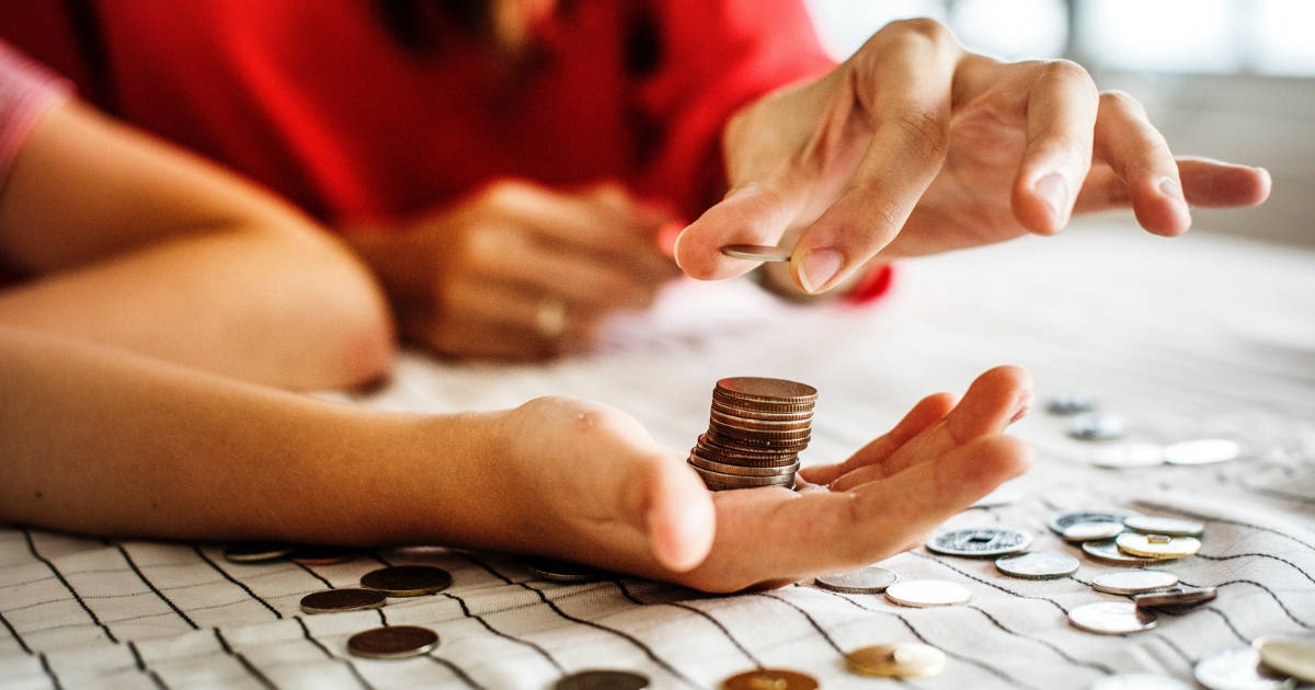 couples hands with coins talking about investing in peak markets