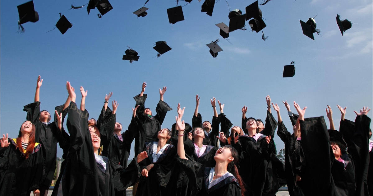 graduates throwing their caps into the air