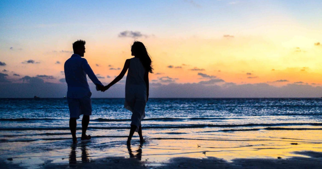 couple walking on beach holding hands trying to understand social security payments