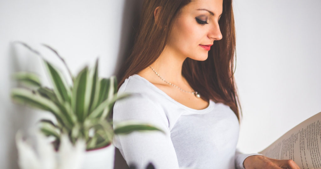 woman sitting on bed reading The Behavior Gap