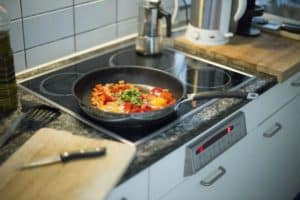 Pan on stove cooking vegetables and eggs