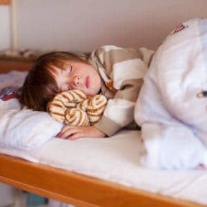 Little boy sleeping on bunk bed