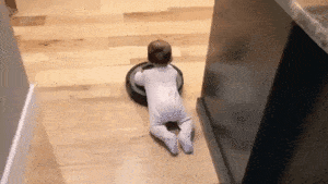 Baby riding on a Roomba