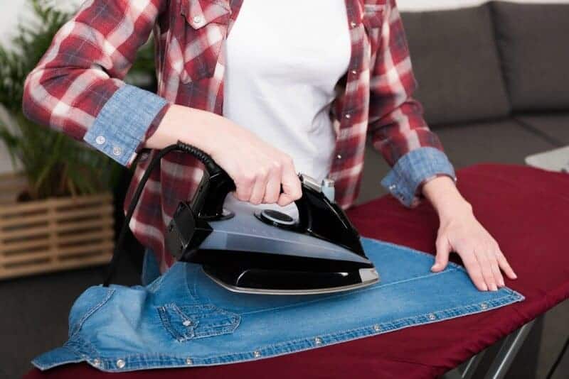 Woman ironing a jean shirt