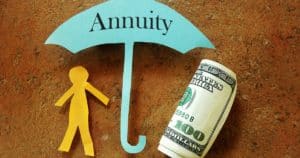 Annuity umbrella over a paper cutout person and hundred dollar bill