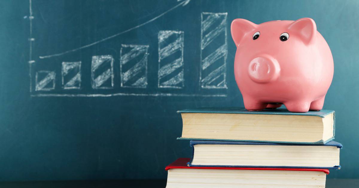 Piggy bank on books with blackboard - Should you refinance your student loans?