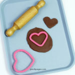 Valentine's Crafts Chocolate Playdough Hearts on pan with cookie cutter