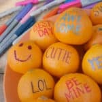 cuties fruit with phrases written on them in marker for a Valentine's Day craft