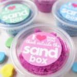 kinetic sand in small containers with Valentine's Day message for kids