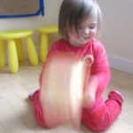 Toddler creating a Valentine's Day craft using the shake painting technique