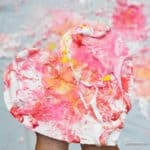 child holding a Valentine's Craft made with shaving cream and paint