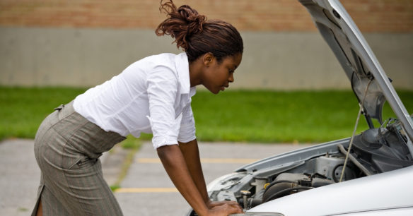 woman standing over broken down car departing whether to buy a car or fix hers