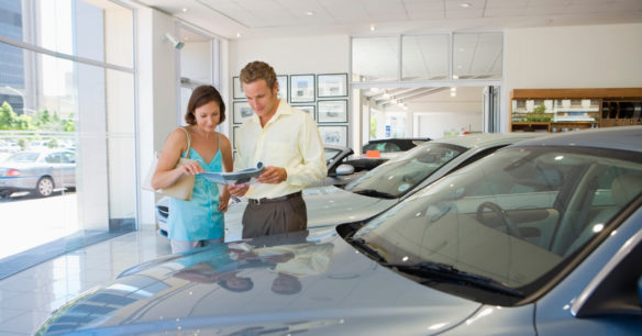 couple buying a car from a dealership showroom