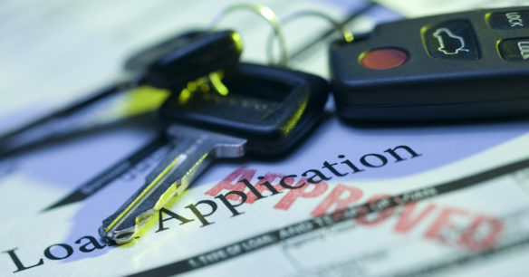 keys sitting on loan application to buy a car