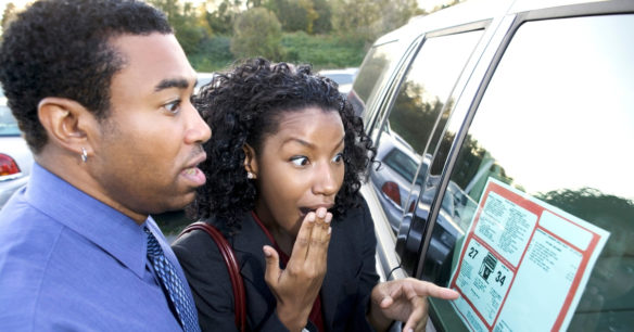 couple looking at price tag of car they are interested in buying