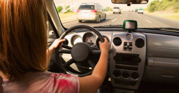 woman test driving vehicle on highway before deciding if she will buy a car