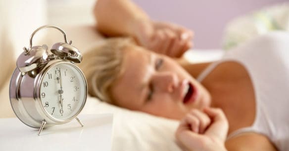 woman stretching after alarm clock goes off to return to work after maternity leave