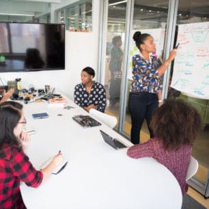 woman returns to work after maternity leaving leads a team meeting discussing the customer journey