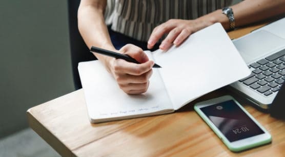 woman sitting at desk planning her next travel hacking trip