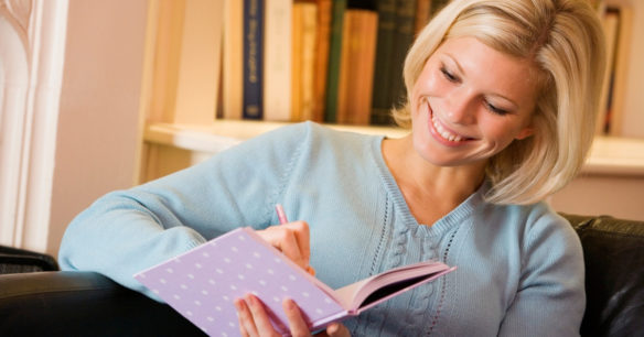 woman sitting on couch journaling about everything she wants out of life