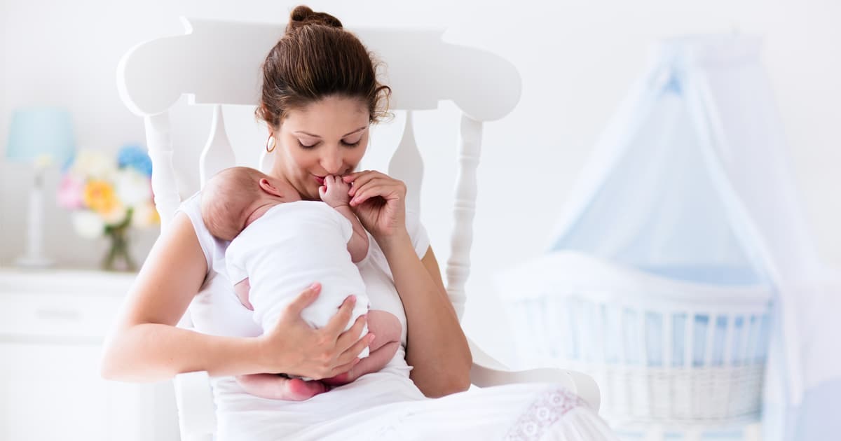 new mom with newborn in nursery